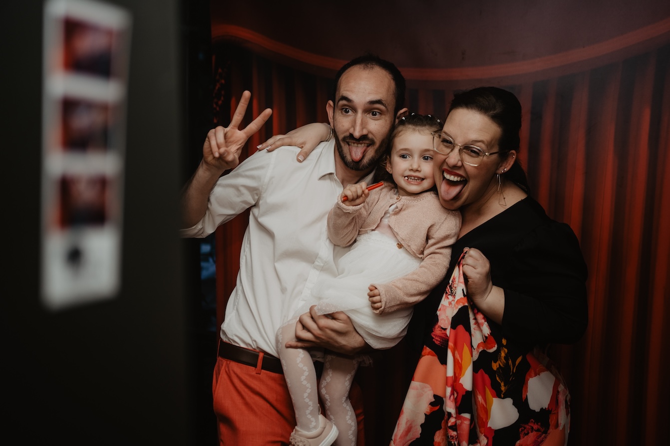 Familia capturando recuerdos inolvidables con el fotomaton retro en una boda en Barcelona